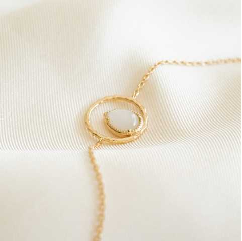Pulsera chapada en oro con piedra de luna en forma de gota de agua rodeada por un anillo