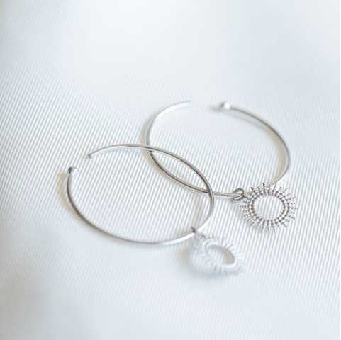 Pendientes de aro de plata rodiada con pequeños soles colgantes