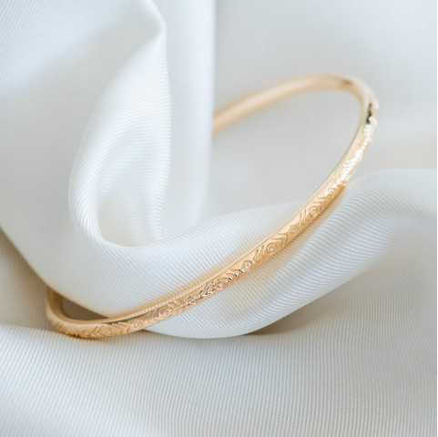 Pulsera rígida fina con grabados dorados