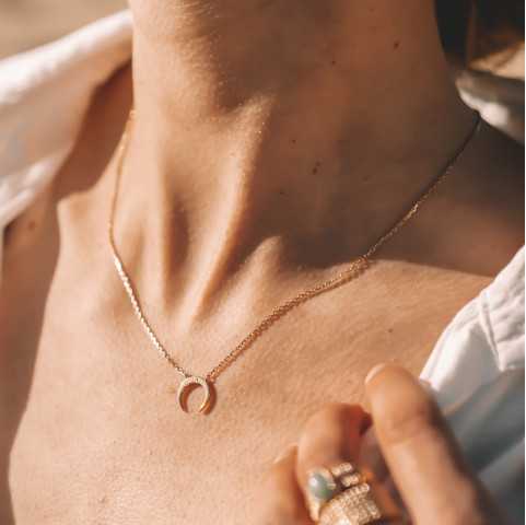 Collar de media luna chapado en oro con una piedra de circonio